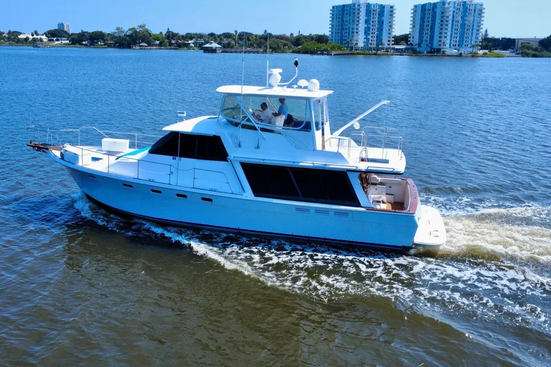 Perseverance Yacht Photos Pics 1989 Bayliner 4588 Motoryacht cruising on a sunny day, with cityscape in the background.