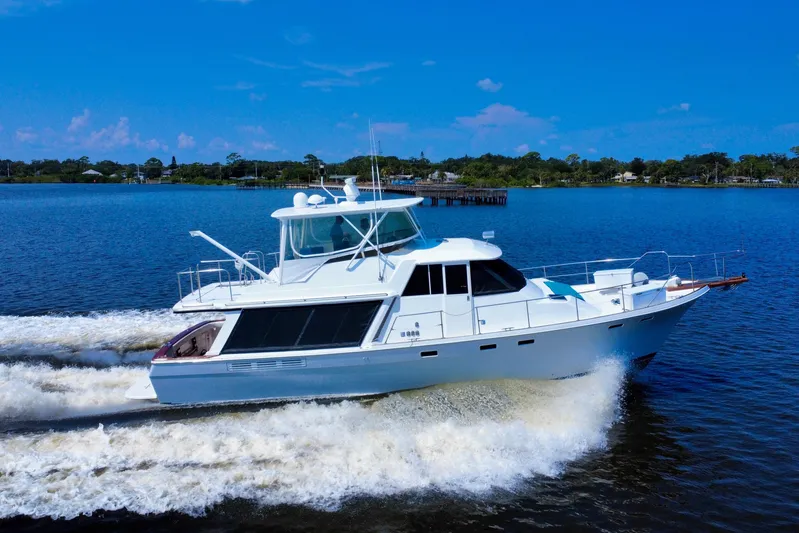 Perseverance Yacht Photos Pics 1989 Bayliner 4588 Motoryacht cruising on a sunny day, creating waves in calm waters.