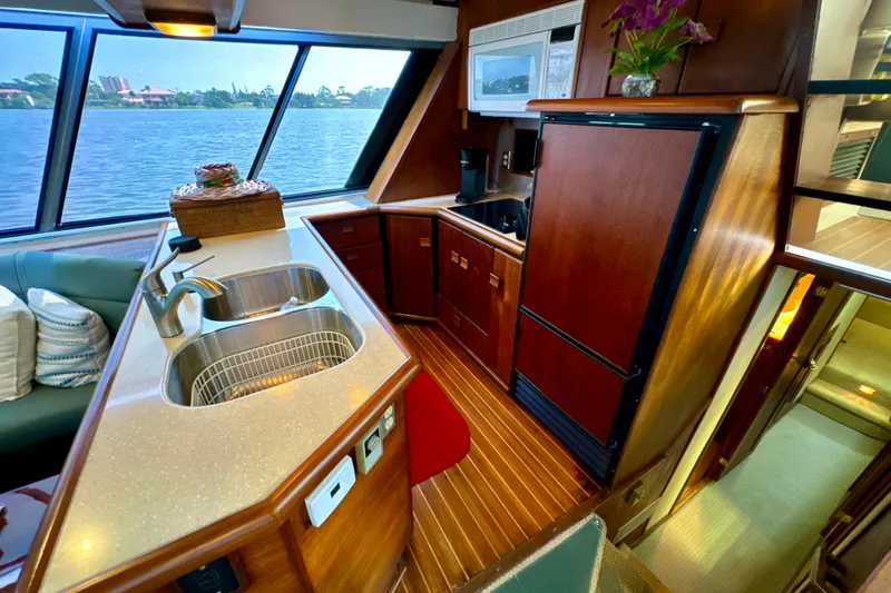 Perseverance Yacht Photos Pics Luxurious kitchen interior of 1989 Bayliner 4588 Motoryacht with wood cabinetry and water view.