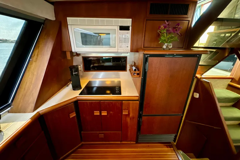 Perseverance Yacht Photos Pics 1989 Bayliner 4588 Motoryacht kitchen with wooden cabinetry, microwave, and stove.