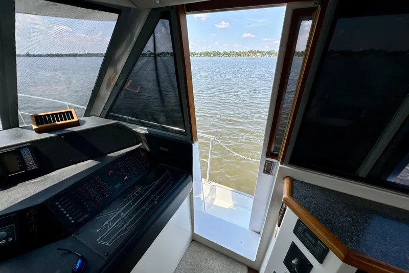 Perseverance Yacht Photos Pics 1989 Bayliner 4588 Motoryacht helm view with water and shoreline in background.