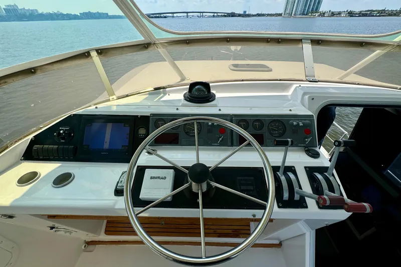 Perseverance Yacht Photos Pics 1989 Bayliner 4588 Motoryacht helm with steering wheel and navigation controls, overlooking water.