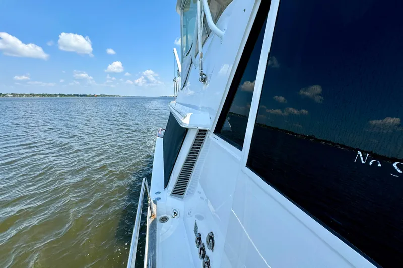 Perseverance Yacht Photos Pics 1989 Bayliner 4588 Motoryacht cruising on a calm lake under a clear blue sky.