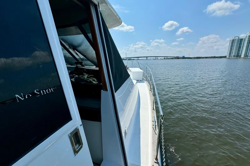 Perseverance Yacht Photos Pics 1989 Bayliner 4588 Motoryacht cruising on a sunny day near city skyline and bridge.