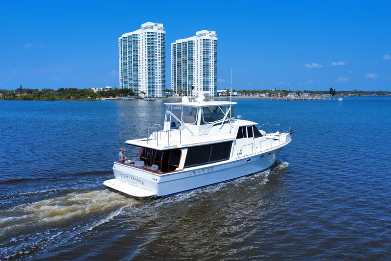 Perseverance Yacht Photos Pics 1989 Bayliner 4588 Motoryacht cruising on a sunny day near high-rise buildings.