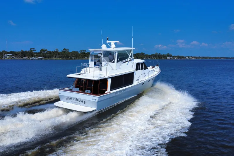 Perseverance Yacht Photos Pics 1989 Bayliner 4588 Motoryacht cruising on a sunny day, creating waves in the water.