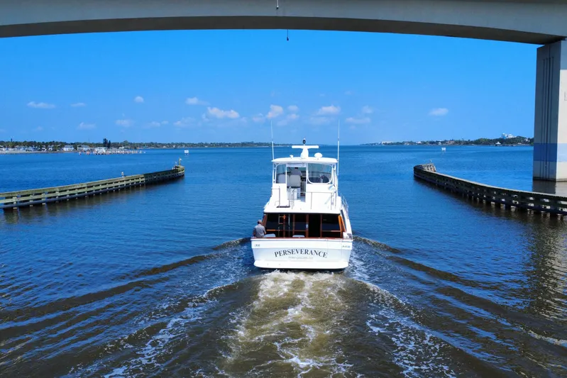 Perseverance Yacht Photos Pics 1989 Bayliner 4588 Motoryacht cruising under a bridge on a sunny day.