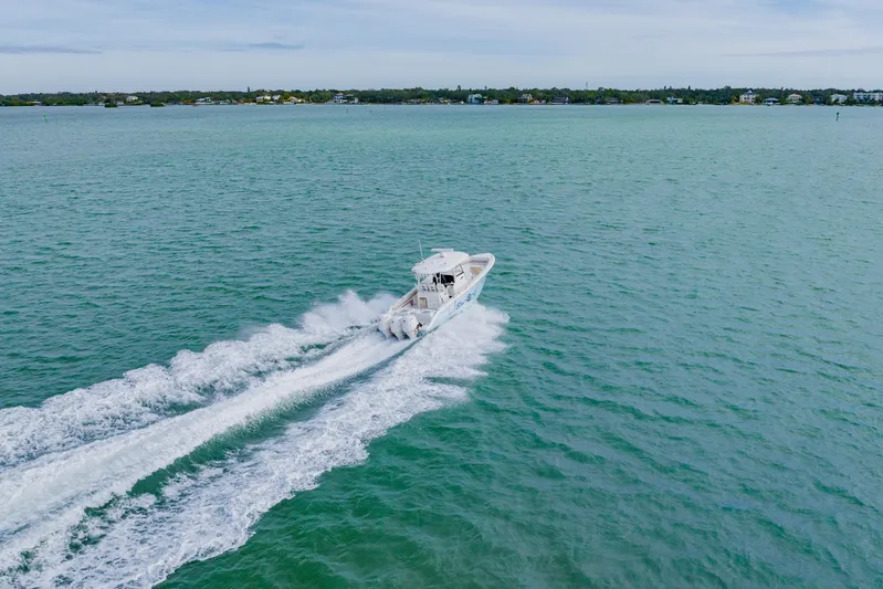  Yacht Photos Pics 2017 Cobia 344 Center Console boat cruising on open water, creating a wake.