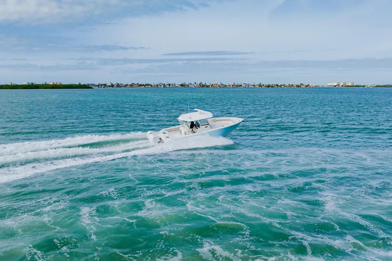  Yacht Photos Pics 2017 Cobia 344 Center Console cruising on turquoise ocean waters.