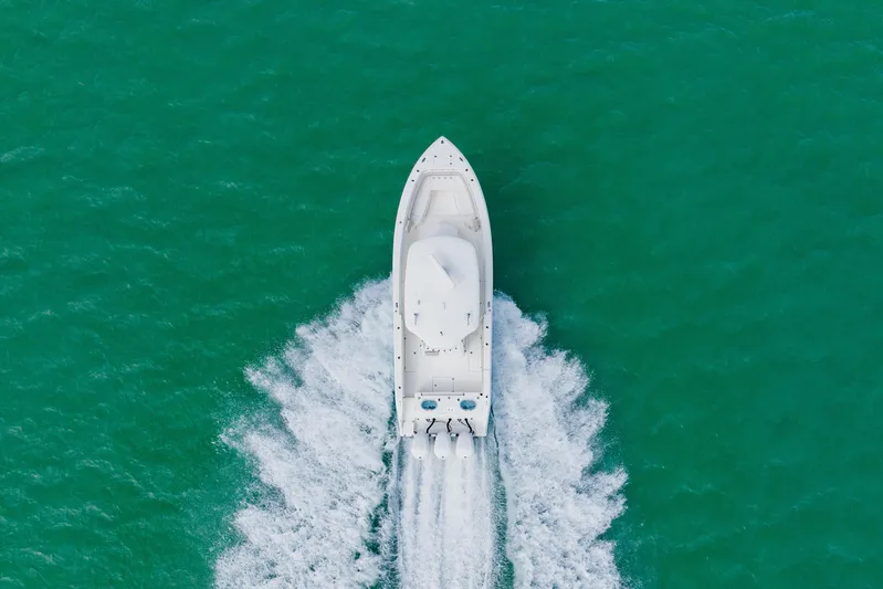  Yacht Photos Pics Aerial view of 2017 Cobia 344 Center Console boat cruising on turquoise water.