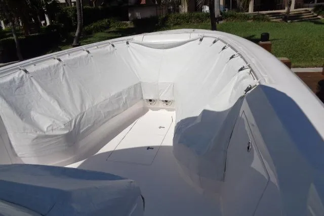  Yacht Photos Pics 2020 Intrepid 345 Nomad FE boat interior with protective cover, showcasing spacious seating area.