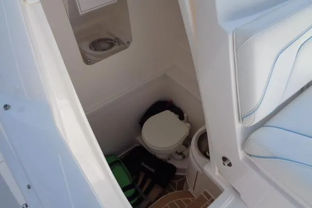  Yacht Photos Pics 2020 Intrepid 345 Nomad FE boat interior with compact bathroom and seating area.