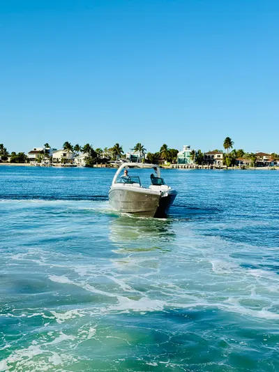  Yacht Photos Pics 2020 Monterey 328 SS boat cruising on a sunny day near coastal homes.