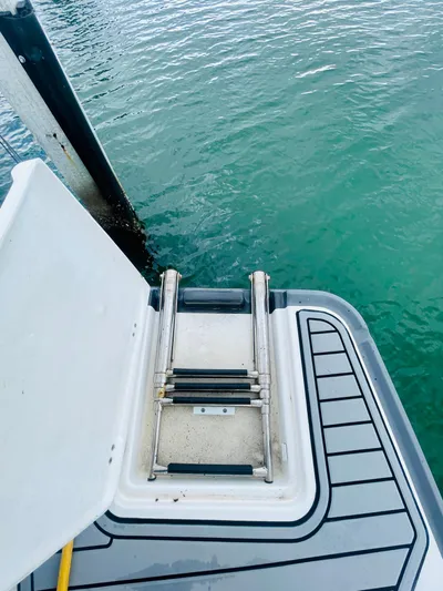  Yacht Photos Pics Boat ladder on a 2020 Monterey 328SS Super Sport, docked by clear water.