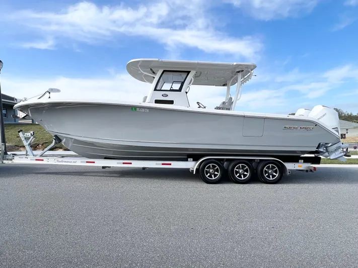  Yacht Photos Pics 2022 Sea Pro 320 DLX Offshore boat on trailer, side view, under clear blue sky.