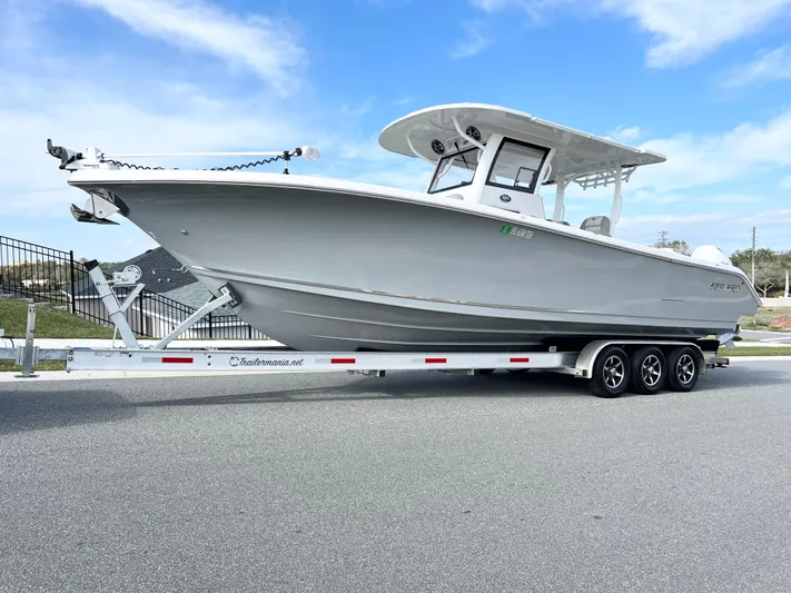  Yacht Photos Pics 2022 Sea Pro 320 DLX Offshore boat on trailer, parked on a road under a clear blue sky.
