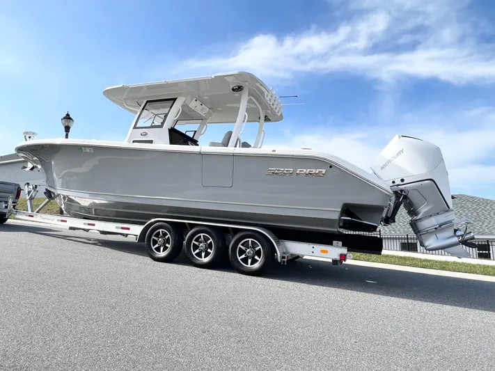  Yacht Photos Pics 2022 Sea Pro 320 DLX Offshore boat on trailer, parked on a sunny street.