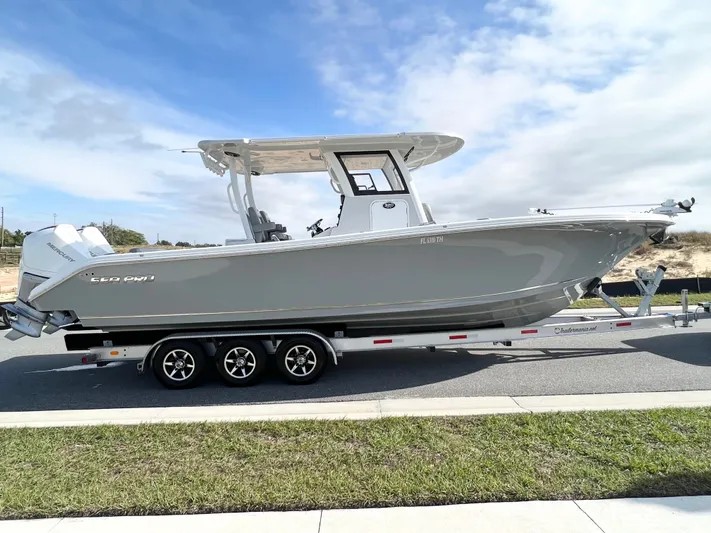  Yacht Photos Pics 2022 Sea Pro 320 DLX Offshore boat on trailer, parked on road, under clear sky.