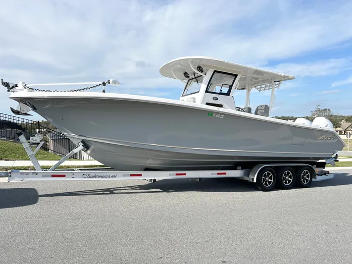  Yacht Photos Pics 2022 Sea Pro 320 DLX Offshore boat on trailer, parked on a street.