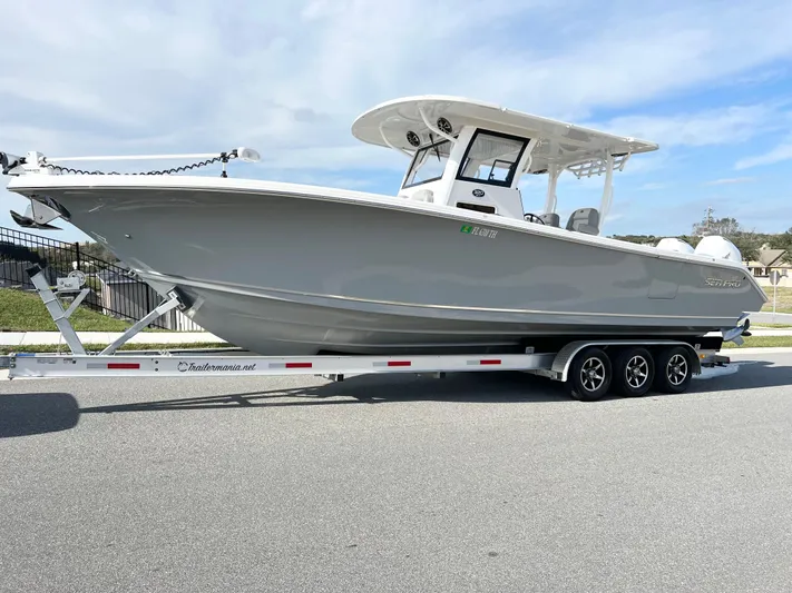  Yacht Photos Pics 2022 Sea Pro 320 DLX Offshore boat on a trailer, parked on a road.