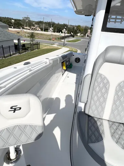  Yacht Photos Pics 2022 Sea Pro 320 DLX Offshore boat interior with quilted seats and coastal view.