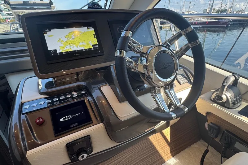 Custom Order Yours Today! Yacht Photos Pics 2026 Cobrey 45 FLY yacht helm with navigation display and sleek steering wheel.