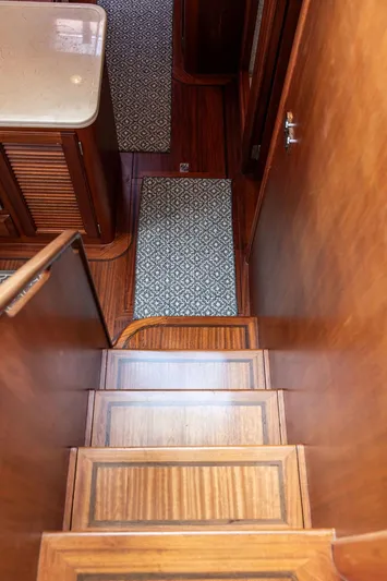 Grace Yacht Photos Pics Staircase inside 2007 Vicem 54 Classic Flybridge yacht with wooden finish and patterned rugs.