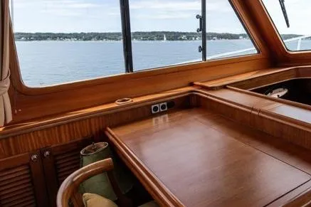 Grace Yacht Photos Pics 2007 Vicem 54 Classic Flybridge interior with wooden table, overlooking serene waters.