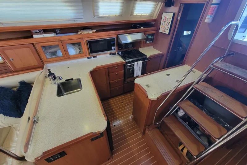 Slip Aweigh Yacht Photos Pics Luxurious 2009 Hunter 49 yacht interior with modern kitchen and wooden stairs.