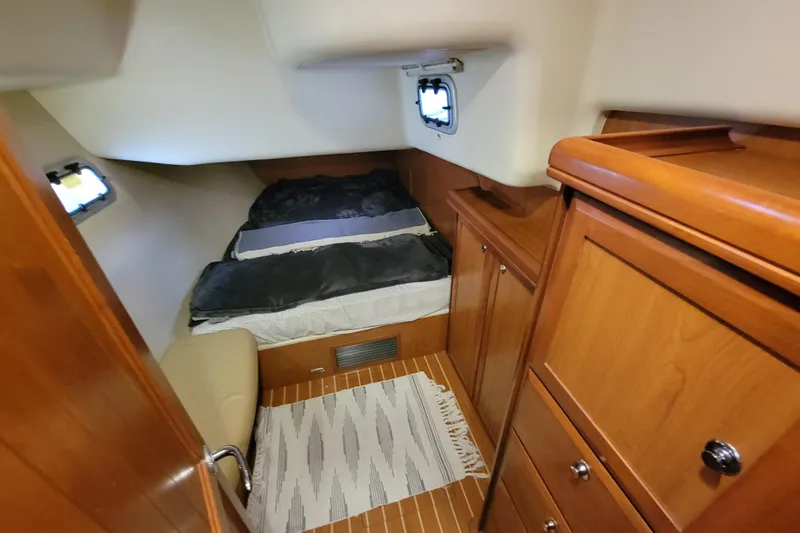 Slip Aweigh Yacht Photos Pics Cozy cabin interior of 2009 Hunter 49 yacht with wooden furnishings and bed.