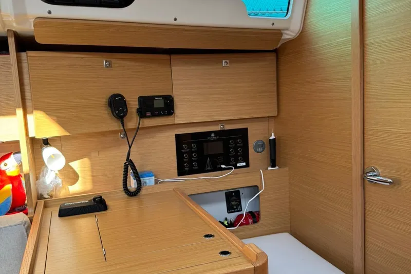 Insania Yacht Photos Pics Interior of 2019 Dufour 360 Grand Large yacht with navigation equipment and wooden cabinetry.