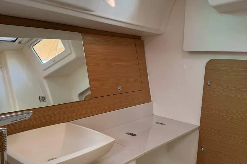 Insania Yacht Photos Pics 2019 Dufour 360 Grand Large yacht bathroom with modern sink and wooden cabinetry.
