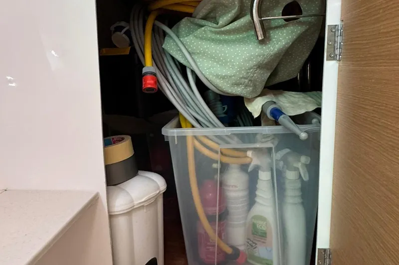 Insania Yacht Photos Pics Storage cabinet on a 2019 Dufour 360 Grand Large yacht with cleaning supplies and hoses.