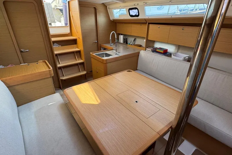 Insania Yacht Photos Pics Interior of 2019 Dufour 360 Grand Large yacht, featuring a cozy dining area and kitchenette.