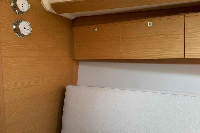 Insania Yacht Photos Pics Interior of 2019 Dufour 360 Grand Large yacht with wooden cabinets and wall instruments.