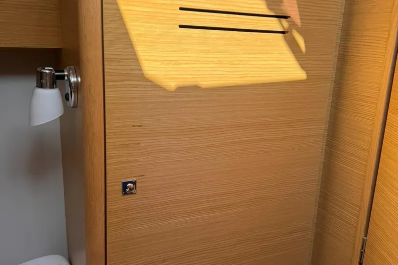 Insania Yacht Photos Pics Wooden interior of 2019 Dufour 360 Grand Large yacht with wall light fixture.