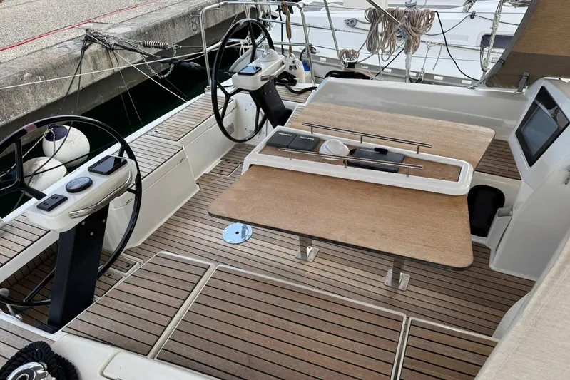 Insania Yacht Photos Pics Cockpit of 2019 Dufour 360 Grand Large sailboat with dual steering wheels and wooden table.
