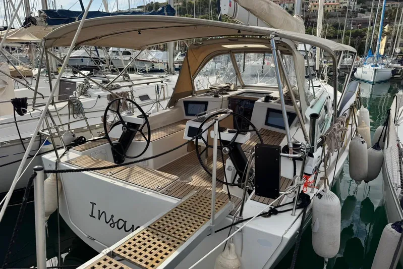 Insania Yacht Photos Pics 2019 Dufour 360 Grand Large sailboat docked, featuring dual steering wheels and spacious cockpit.