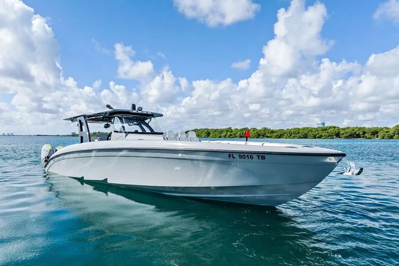 Trigger Yacht Photos Pics 2022 Midnight Express 43' Solstice boat on calm water under a cloudy sky.