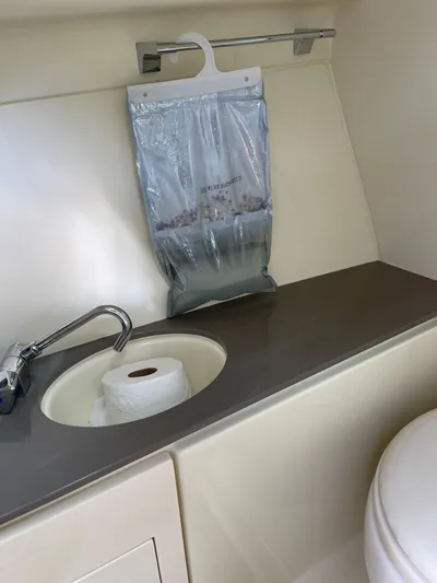  Yacht Photos Pics Chris-Craft 28 Launch GT 2021 boat bathroom with sink, toilet paper, and dehumidifier bag.