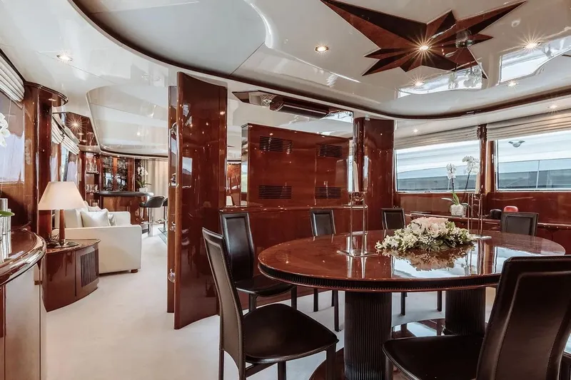 Let It Be Yacht Photos Pics Luxurious interior of 1998 Tecnomarine 118 yacht with elegant dining area and polished wood finishes.