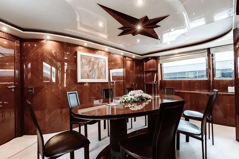 Let It Be Yacht Photos Pics Luxurious dining area on 1998 Tecnomarine 118 yacht with elegant wood paneling and modern decor.