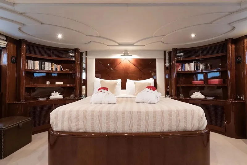 Let It Be Yacht Photos Pics Luxurious bedroom interior on 1998 Tecnomarine 118 yacht with elegant wood finishes and cozy bedding.