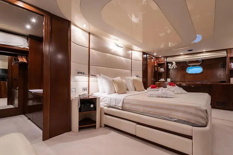 Let It Be Yacht Photos Pics Luxurious Tecnomarine 118 yacht bedroom interior, 1998 model, featuring elegant wood and plush furnishings.