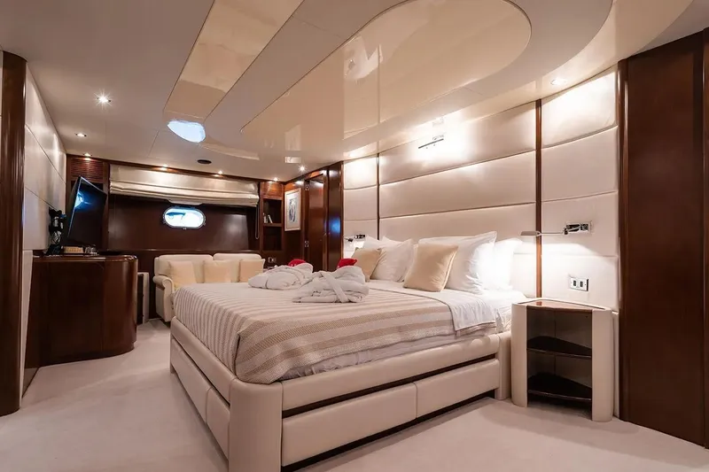 Let It Be Yacht Photos Pics Luxurious bedroom interior of 1998 Tecnomarine 118 yacht with elegant furnishings and ambient lighting.