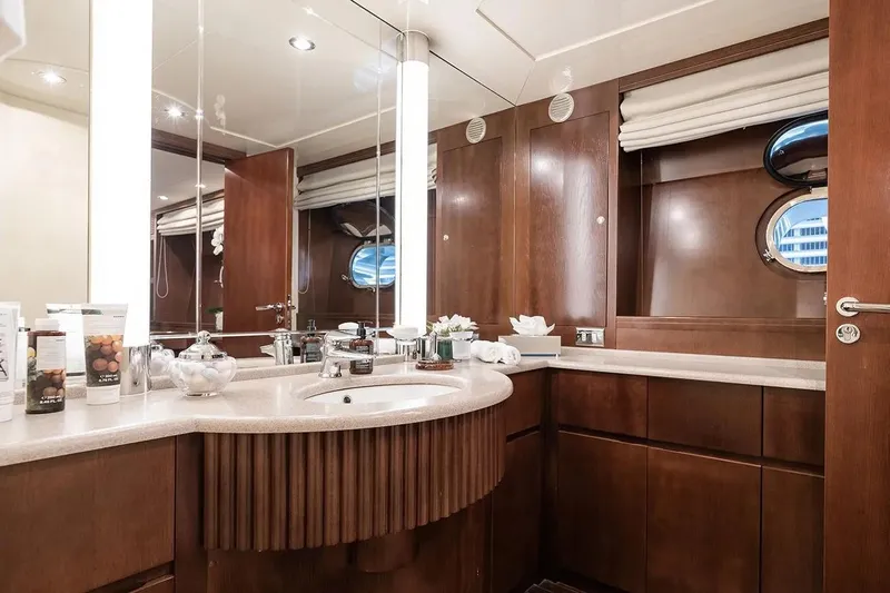 Let It Be Yacht Photos Pics Luxurious Tecnomarine 118 yacht bathroom, 1998 model, featuring elegant wood cabinetry and modern fixtures.