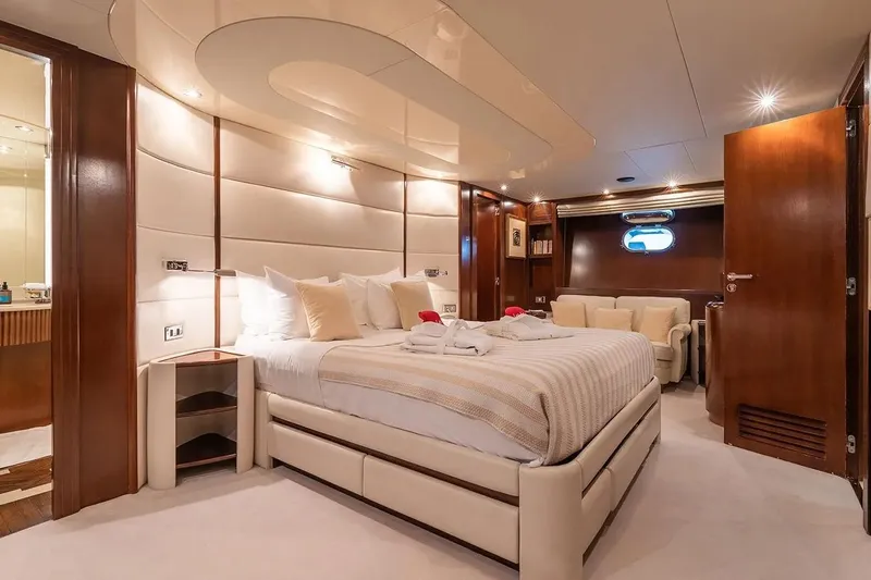 Let It Be Yacht Photos Pics Luxurious bedroom interior on 1998 Tecnomarine 118 yacht, featuring elegant design and cozy furnishings.