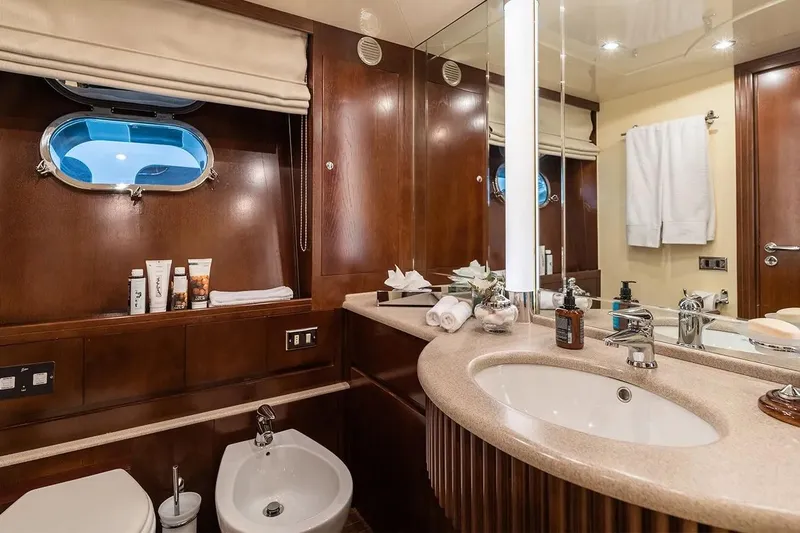 Let It Be Yacht Photos Pics Luxurious Tecnomarine 118 yacht bathroom, featuring elegant wood finishes and modern amenities, 1998 model.