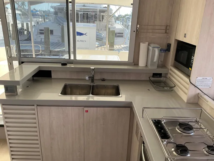 The Dance Yacht Photos Pics Modern kitchen interior on a 2019 Leopard 51 Powercat yacht, featuring dual sinks and a gas stove.