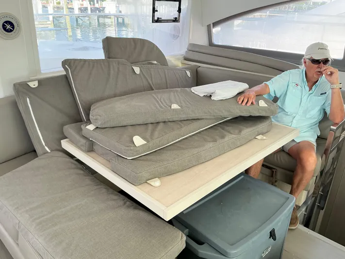 The Dance Yacht Photos Pics 2019 Leopard 51 Powercat interior with stacked cushions and a seated person.